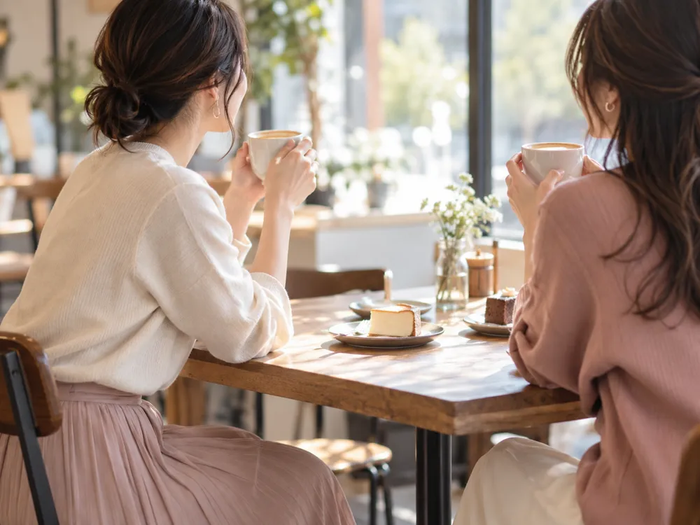 休みの日にカフェで過ごす友人同士のイメージ