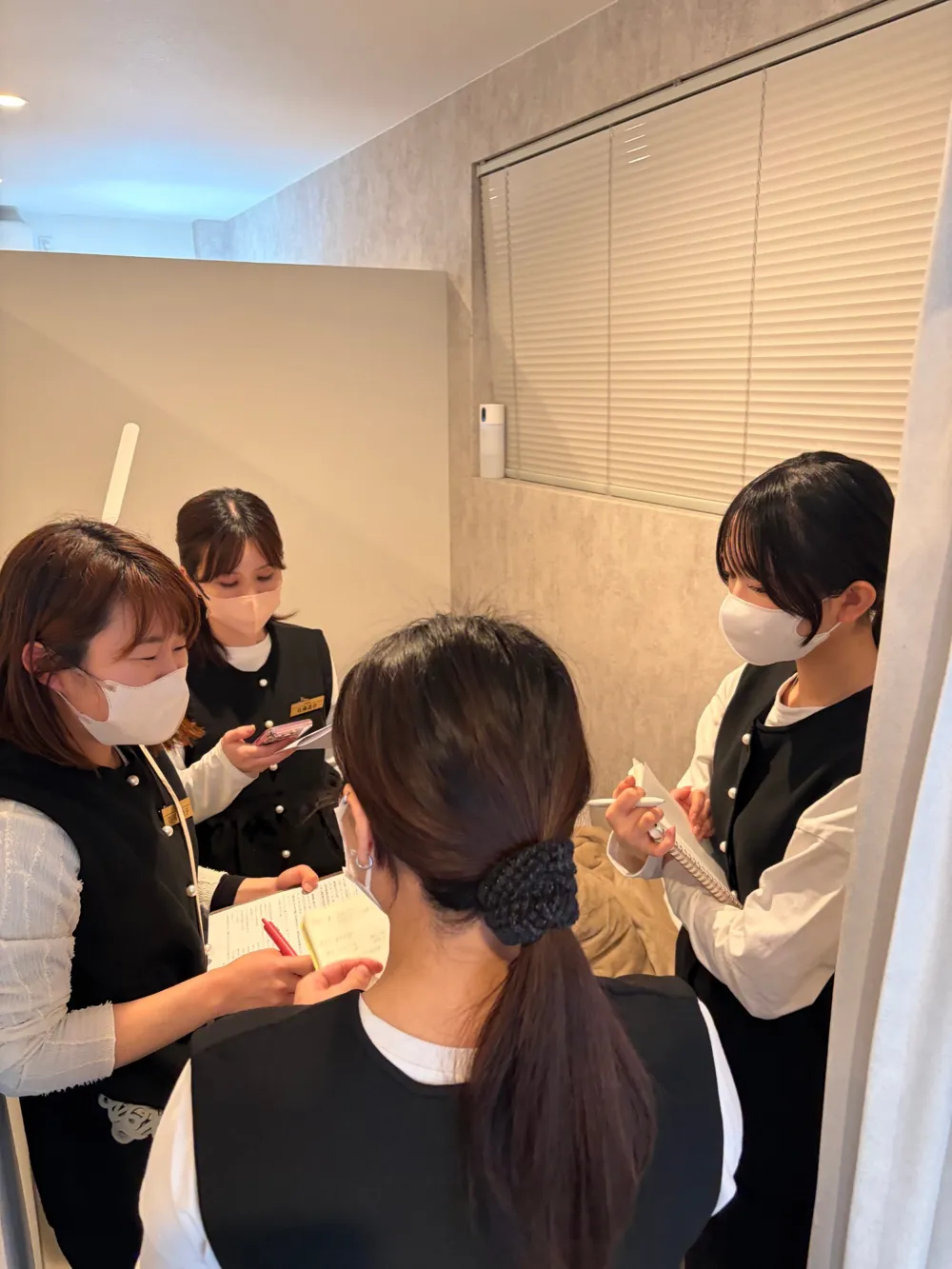 施術スペースでメモを取りながら学ぶスタッフ